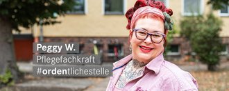 Pflegefachkraft mit roten Haaren Brille und Tattoos laechelt freundlich in die Kamera